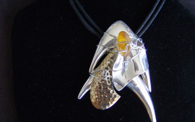 Modern design, amber, sterling silver, brass, pendant on cotton cord adaptable to chain or omega. SOLD